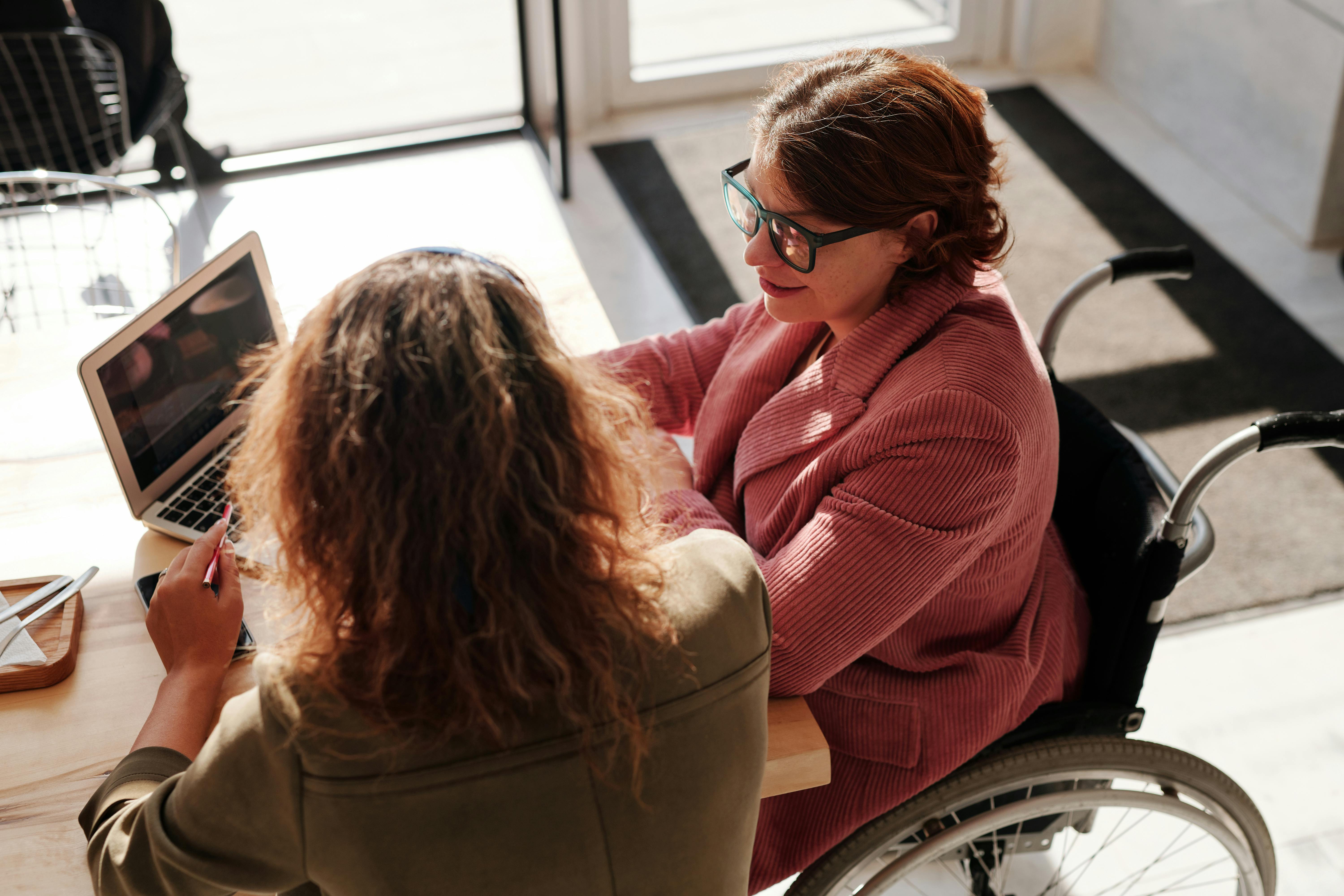 woman talking to other woman in wheel chair